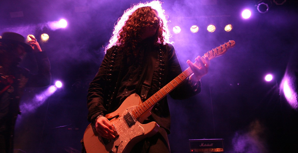 Felipe Rodrigo i The Mercury Riots spelar gitarr i lila scenljus