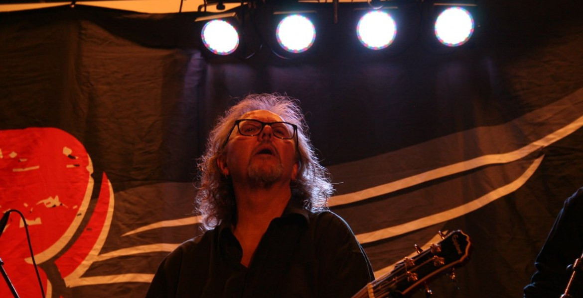 Micke Finell spelar gitarr på scen.