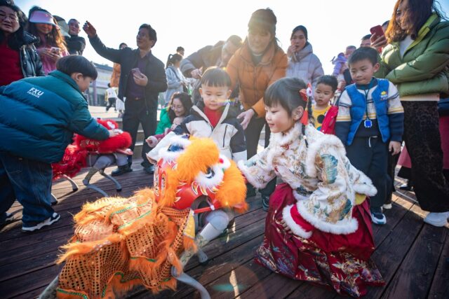 Ett barn interagerar med en robothund i en park i Xinghua, Jiangsu-provinsen, under det kinesiska nyårsfirandet.
