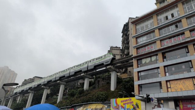 Monorail som kör genom bostadsbyggnader i Kina, symbol för landets infrastrukturutveckling