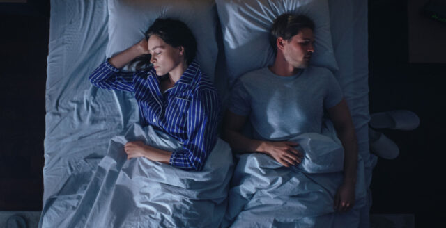 Kvinna och man sover i en säng