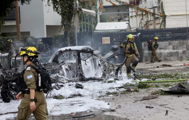 Israeliska räddningsstyrkor vid platsen för ett iranskt anfall i Tel Aviv.