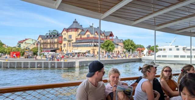 Vy mot Vaxholm från en skärgårdsbåt med Waxholms hotell vid kajen.