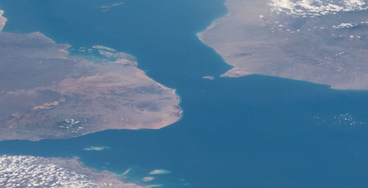 Bab el-Mandeb sett från rymden, med kusterna på båda sidor och ön Perim i sundet.