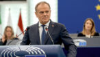 Polens premiärminister Donald Tusk talar i EU-parlamentet med EU-flaggor i bakgrunden.