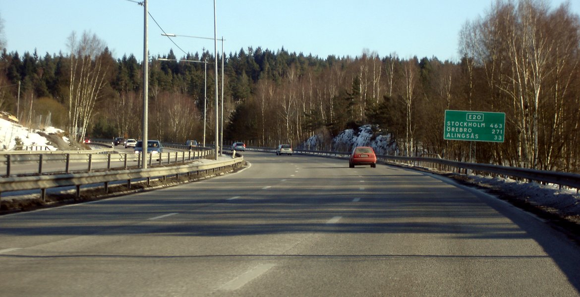 Motorväg E20 öster om Göteborg med skylt mot Alingsås, Vårgårda och Stockholm och bilar i höger körfält.