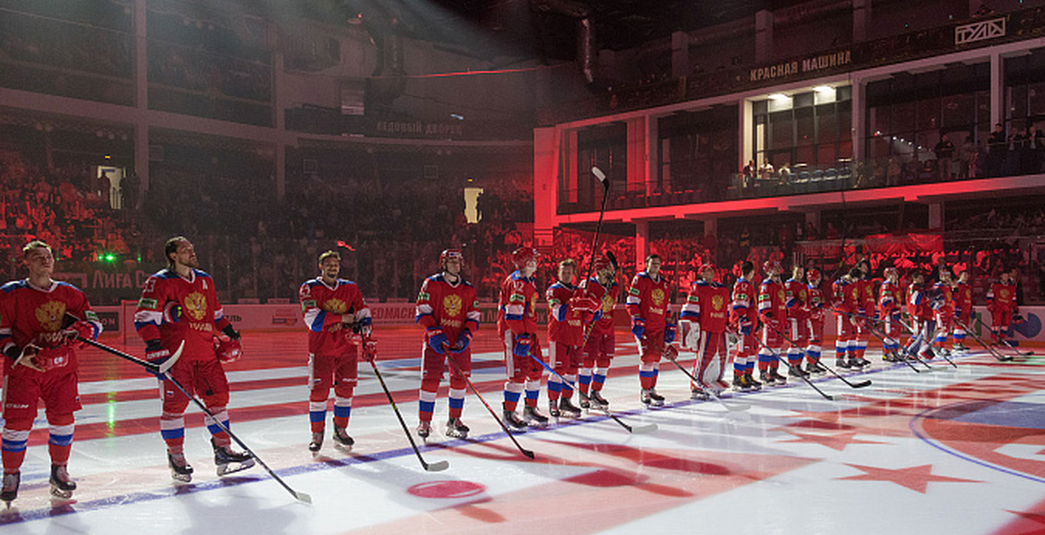 Ryska hockeyspelare i röda matchställ står på rad på isen inför mötet med Belarus den 13 maj 2023.