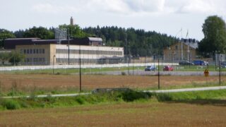 Hallanstaltens byggnader bakom säkerhetsstängsel.