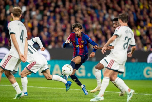 Lamine Yamal i Barcelonas matchställ slår ett inlägg omgiven av Real Madrid-spelare.