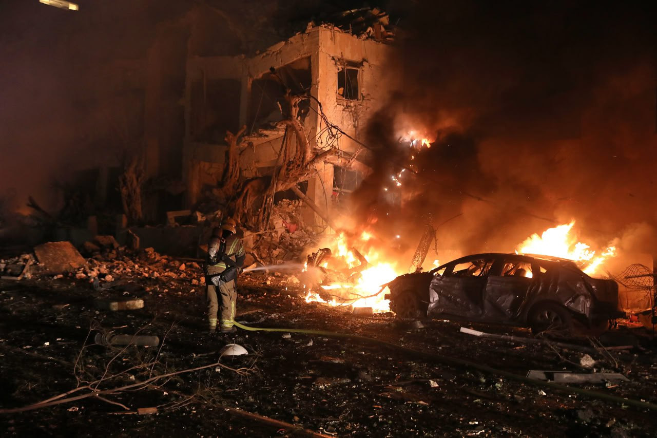 Brandman arbetar vid brinnande bilvrack i Tel Aviv efter iransk missilattack