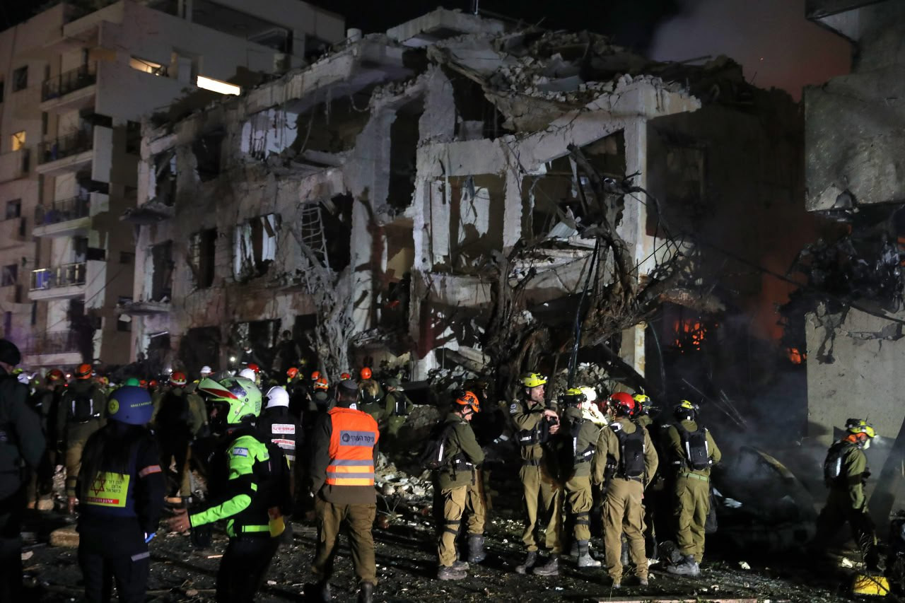 Räddningspersonal vid förstörd byggnad i Tel Aviv efter iransk missilattack