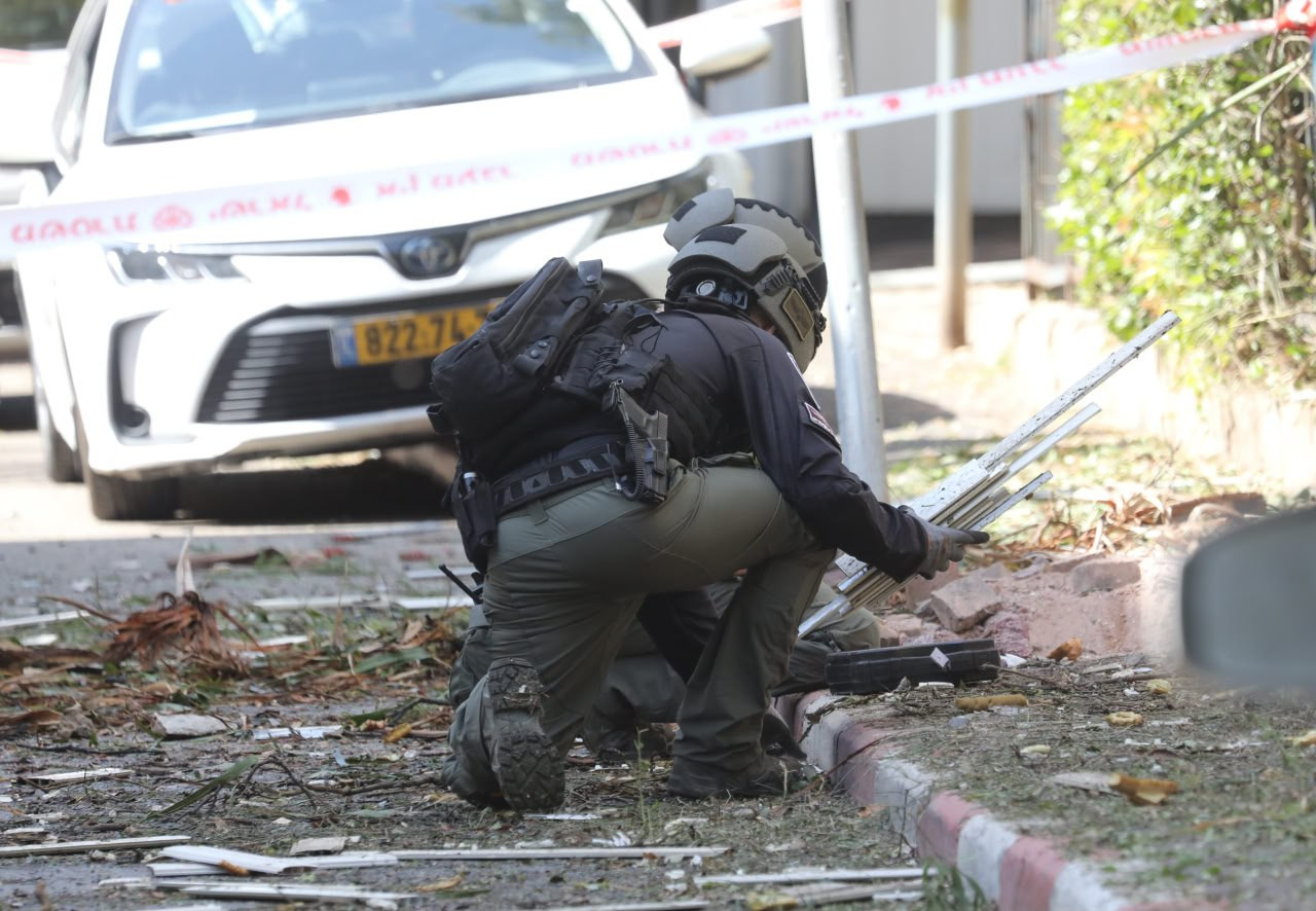Säkerhetspersonal undersöker skadeplats i Tel Aviv efter iransk attack